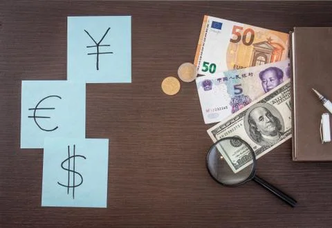 Banknotes and coins lying on notepad, stickers with currency signs and Magnif Stock Photos