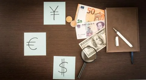 Banknotes and coins lying on notepad, stickers with currency signs and Magnif Stock Photos