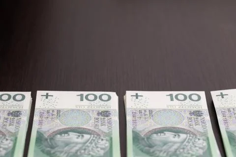 Banknotes evenly distributed on a dark brown desk ready for use. Fotos Stock