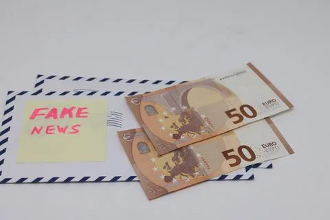 Banknotes on a postal envelope on a light background. Fake news sticker on .. Stock Photos