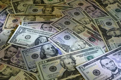 Banknotes of US dollars of different denominations arranged in random order Stock Photos
