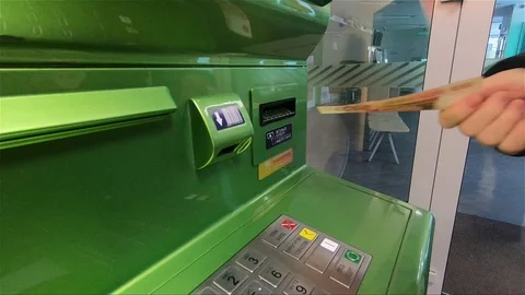 The Bank's client inserts banknotes into the ATM Stock Footage 100871060