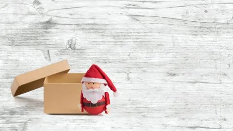 Banner, backdrop or background with a cute Santa Claus Doll and an open box w Stock Photos