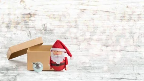 Banner, backdrop or background with a cute Santa Claus Doll and an open box w Stock Photos