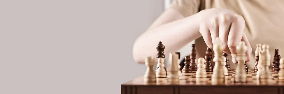 Banner with Faceless boy develops game strategy. Hand holds chess piece and 스톡 사진