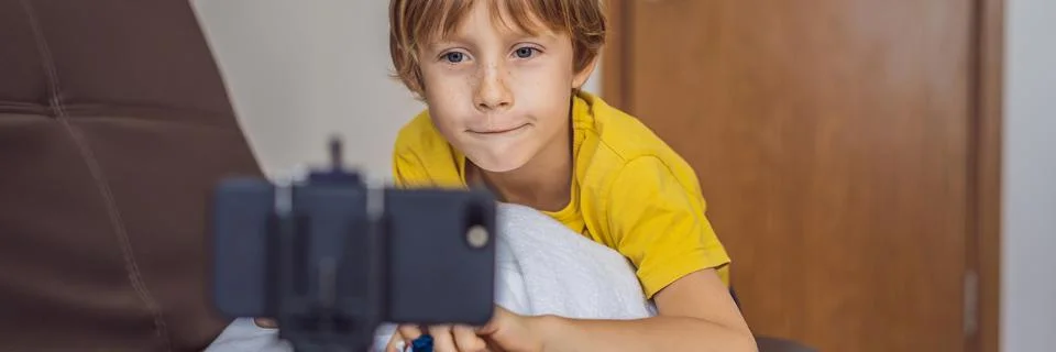 BANNER, LONG FORMAT Staying connected. Happy young boy looking at his mobile Stock Photos
