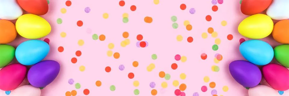 Banner made from colored Easter eggs on pink background with confetti. Stock Photos