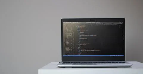 Banner of opened laptop with code on the screen on the table Stock Photos