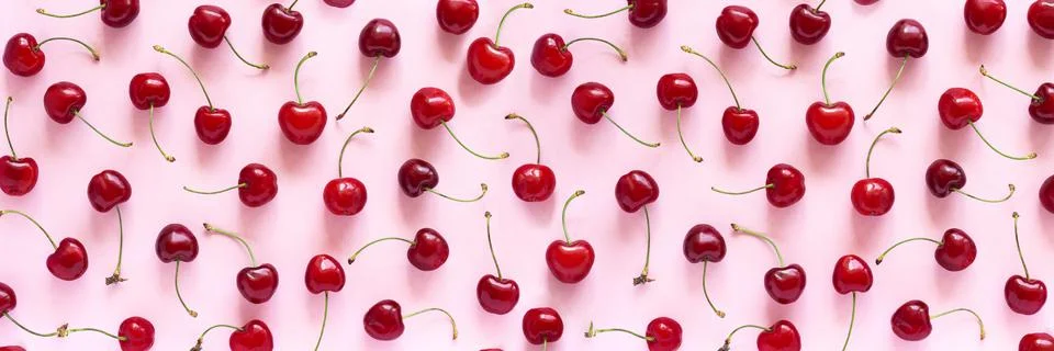 Banner with pattern of red sweet cherry berries on pink background. Flat lay  Stock Photos