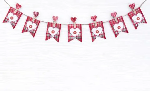 Banner with red checkered flags and wooden hearts on a string Stock Photos