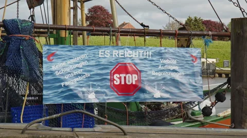 A banner, sign in the Harbor of Greetsiel protesting against a planned ban of Stock Footage 243438720
