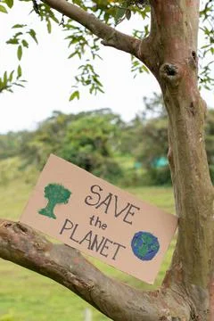 A banner on a tree calling to save the planet. Poster with environmental message Foto stock
