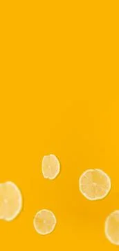 Banner of vertical format flying lemon slices on a yellow background. Stock Photos