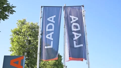 Banners displaying the LADA brand are prominently flying outside a car Stock Footage 344672602