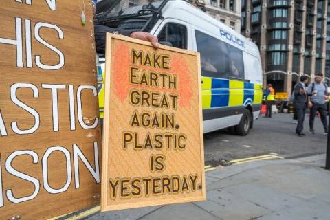 Banners protesting the use of plastic in front of police vans in London Stock Photos