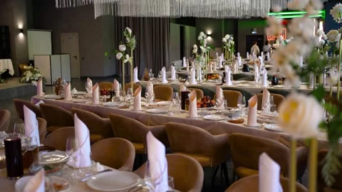 A banquet hall, complete with set tables and a stage, is ready to host guests Stock Footage 271583592