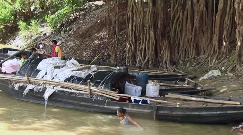 Banyan tree, boats, and bathing pilgrims in India Stock Footage 57745826