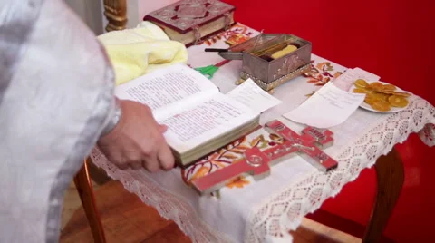 Baptism. The priest holds the holy scripture Stock Footage 68177864