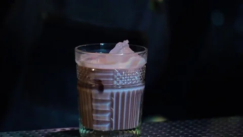 Bar attendent add leaf of mint to the cocktail with nice tender pink color Video stock 70771482