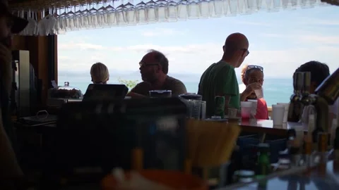 Bar by the beach on a bright sunny day with people having drinks and Stock Footage 169023683