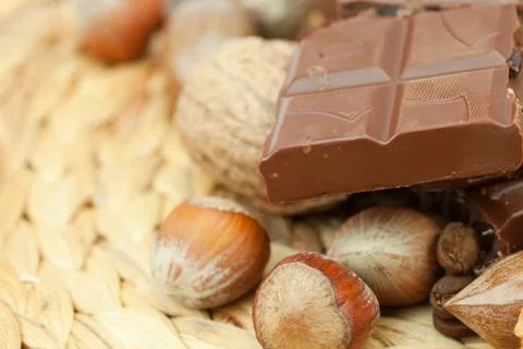 Bar of chocolate and nuts on a wicker mat Stock-Fotos