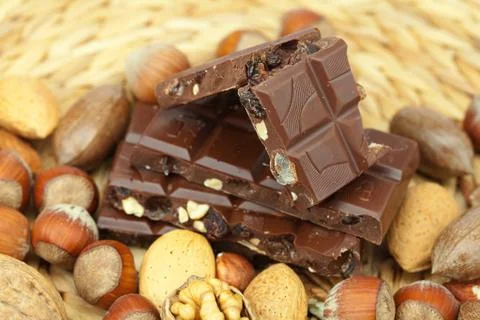 Bar of chocolate and nuts on a wicker mat Foto stock