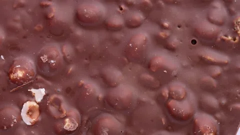Bar of chocolate with hazelnuts, rotation in circle. Stock Footage 243351156