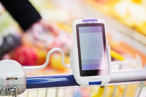 Bar code scanner on shopping cart in store. Concept of modern gadgets Stock-Fotos