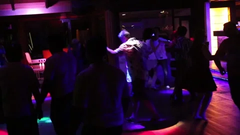 In the Bar couples are dancing  for DJ music with colorful party lights Stock Footage 134532593