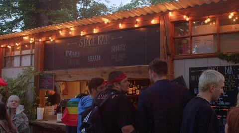 Bar in evening light. In queue, customers dancing, waiting purchase drink. Foto stock