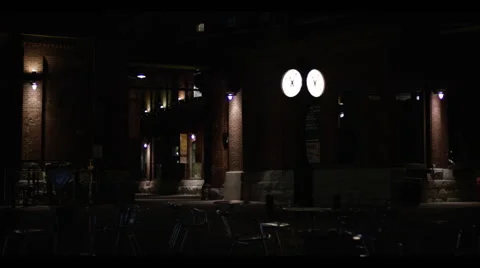 Bar exterior night with bright clock illuminating Stock Footage