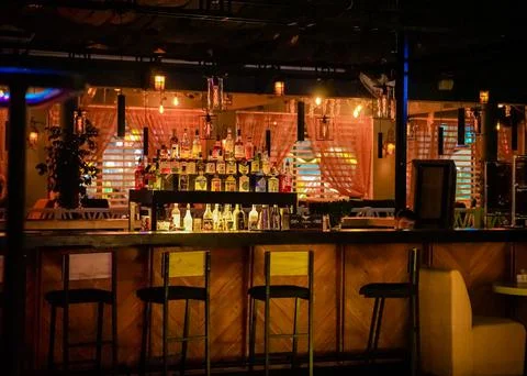 Bar interior with empty black chairs and a shelf of various alcohol. anapa ci Stock Photos