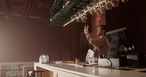 Bar manager wiping glasses while preparing for opening Stock Footage 239166815
