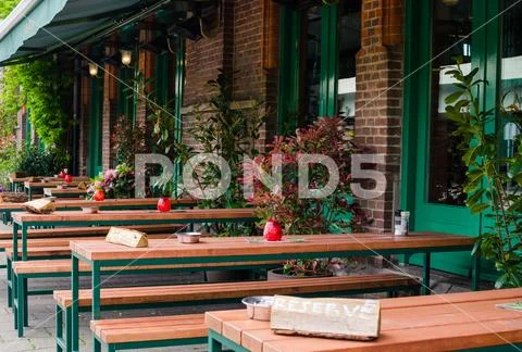 Bar in Oost, Amsterdam, Netherlands. Outside street view of long wooden table Stock Photos
