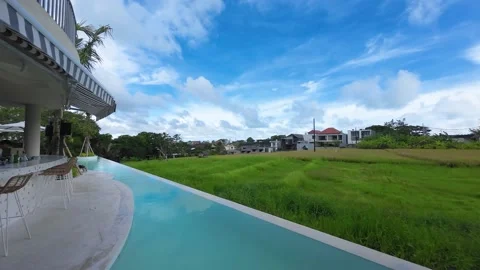 A bar, pool and paddy fields with a clear blue sky Stock Footage 237747253