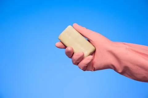 Bar of soap held in hand by Caucasian male with latex cleaning glove isolated Stock-Fotos