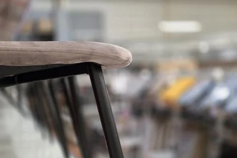 A bar stool on background shows blurred details of store Stock Photos