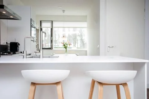 Bar stools by modern white kitchen island, new and clean modern design Stock Photos
