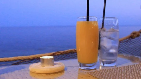 In a bar on a table on the shore against the blue sea stand two glasses with coc Stock Footage 115664210