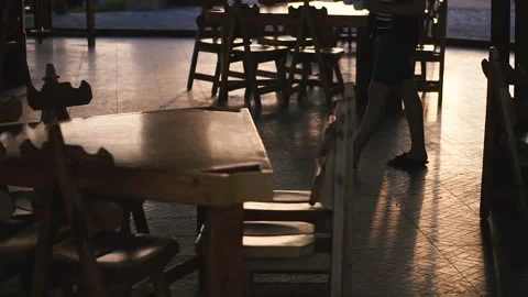 Bar. Tables illuminating the sunset in the background is the silhouette of a  Stock Footage 107179339