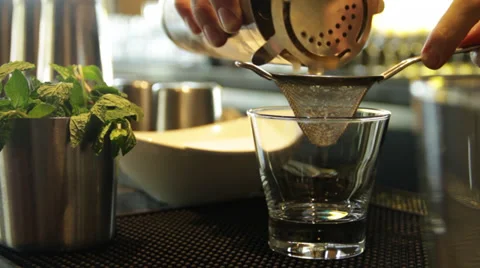 A bar tender prepares the bar drink, strain in a glass beaker Stock Footage 35404582