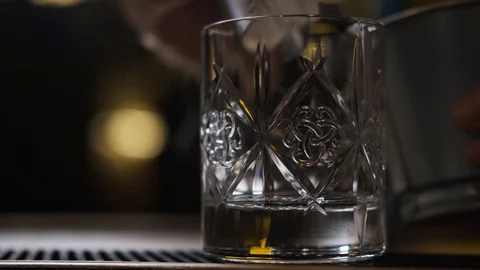 Bar there is glass,ice cubes fall into glass,bartender puts ice and takes glass Stock Footage 129799888