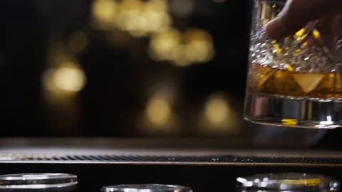 Bar there is glass,ice cubes fall into glass,bartender puts ice and takes glass Stock Footage 129800168