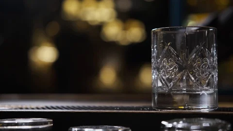 Bar there is glass,ice cubes fall into glass,bartender puts ice and takes glass Stock Footage 129800311