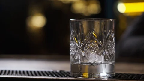 Bar there is glass,ice cubes fall into glass,bartender puts ice and takes glass Stock Footage 129800426