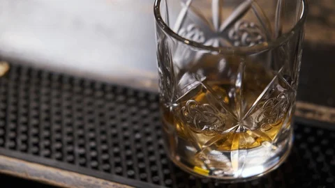 Bar there is glass,ice cubes fall into glass,bartender puts ice and takes glass Stock Footage 129800439
