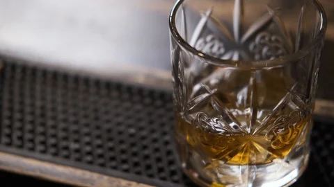 Bar there is glass,ice cubes fall into glass,bartender puts ice and takes glass Stock Footage 129800470