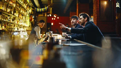 Bar visitors choosing drinks at counter closeup. Two friends ordering cocktails Stock Footage 319789452