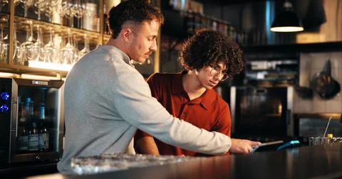 Bar, waiter and manager with tech for order, teamwork and training of employee Stock Photos