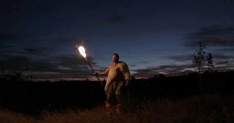 Barbarian with torch exploring countryside. Low angle of man with bow and Vídeos de archivo 141225232